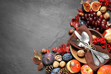 Flat lay composition with cutlery, autumn vegetables and fruits on grey background, space for text....
