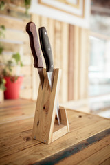 Close-up of knives in wooden stand on table