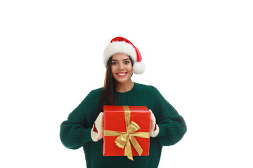 Happy young woman in Santa hat with Christmas gift on white background