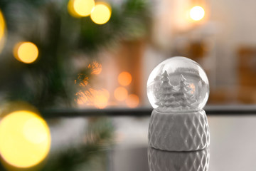 Decorative Christmas snow globe on mirror surface