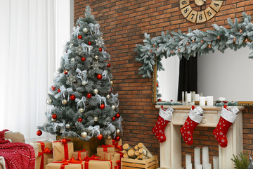 Stylish interior with beautiful Christmas tree and decorative fireplace