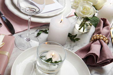 Elegant festive table setting on white marble background, closeup
