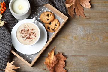 Flat lay composition with cup of hot drink on wooden table, space for text. Cozy autumn atmosphere