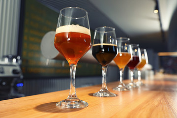 Different sorts of beer on wooden bar counter