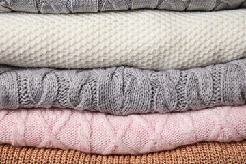 Stack of knitted clothes as background. Cozy autumn