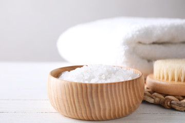 Fototapeta na wymiar White sea salt for spa scrubbing procedure on wooden table