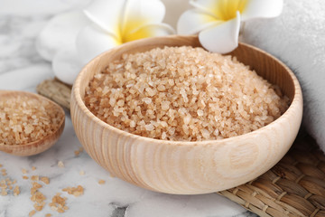 Salt for spa scrubbing procedure on white marble table