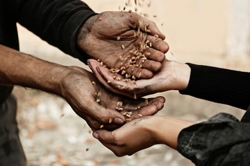 Poor homeless people sharing food outdoors, closeup