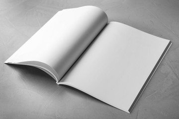 Blank open book on light grey stone background. Mock up for design