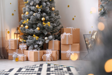 Stylish room interior with beautiful Christmas tree and gift boxes