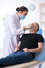 Old man visiting young doctor for plastic surgery