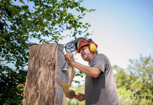 Wood carver carving sculpture, using chisel