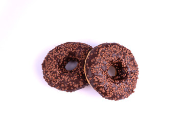 on a white background highlighted in close-up two sweet donuts coated with chocolate icing and powder