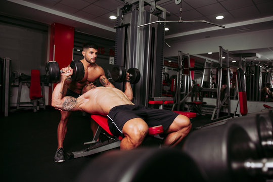Muscular men training in gym