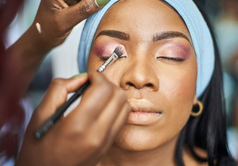 Close up of visagiste applying eyeshadow on woman