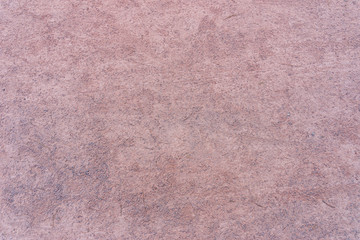 Fondo de suelo de tierra color rosa con textura de arena y pequeñas piedras