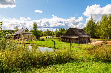 Obraz premium Village house with outbuildings and small pond