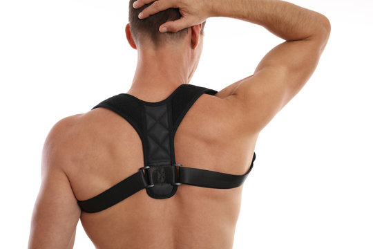 Attractive muscular man with posture corrector. Scoliosis, Kyphosis treatment