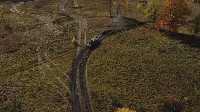 Armoured personnel carrier goes on the field. APC. Aerial video. Drone video. Autumn yellow trees and blue sky. Military trainings