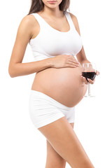 Pregnancy. Young, pregnant woman, on isolated white backgrou.nd holding glass of alcohol