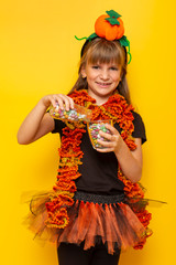 Child pouring a glass of candies for Halloween