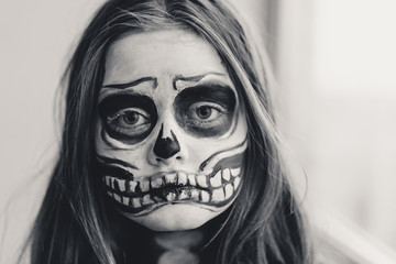 Close-up black and white portrait of a teenage girl with homemade Halloween holiday make up