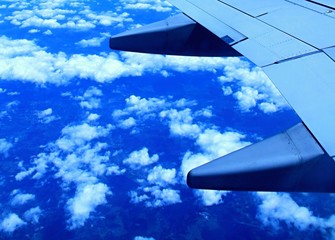 Naklejka na ściany i meble airplane wings with clouds stock photo