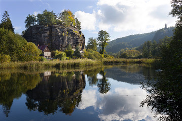 Fototapeta na wymiar Impregnable medieval rock castle Sloup from the 13th century with Castle pond in northern Bohemia, Czech Republic