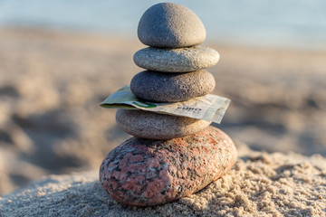 5 EUR banknote and pebble