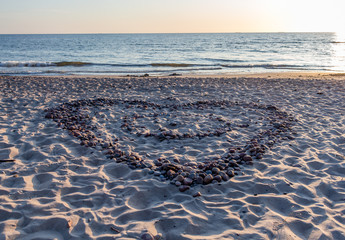 Naklejka premium Pebble heart on the beach