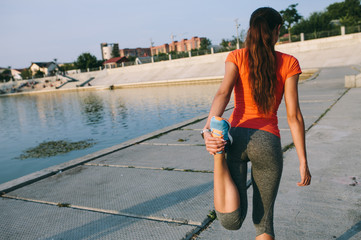 Young sporty woman doing stretching in city. Sport girl