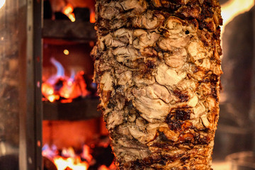 Close up shot of stacked meat roasting to be used in preparation of traditional Greek dish gyros or...