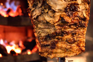 Close up shot of stacked meat roasting to be used in preparation of traditional Greek dish gyros or...