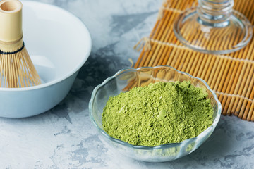 Ingredients for making matcha green tea. Powdered green tea, whisk and bowl. Close-up photo.