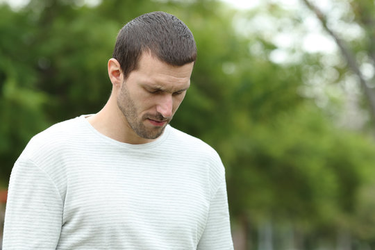 Sad Man Walking Alone Looking Down In A Park