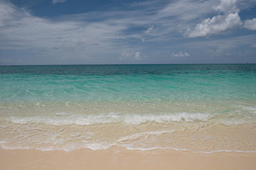 Fototapeta na wymiar Crystal clear waters and pinkish sands on empty seven mile beach on tropical carribean Grand Cayman Island