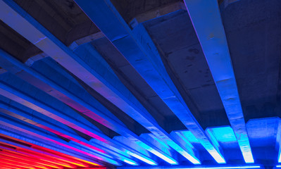 Bridge with neon blue and red lights underneath
