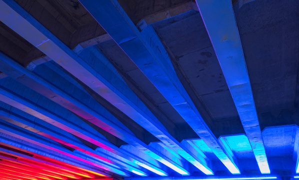 Bridge with neon blue and red lights underneath