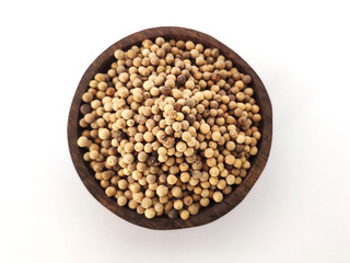 Piper Albi Linn / White Pepper (known as Lada or Merica Putih in Indonesia) on a wooden bowl at white background