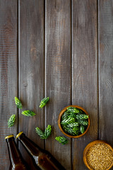 Barley and hop for making beer on dark wooden background top view copy space