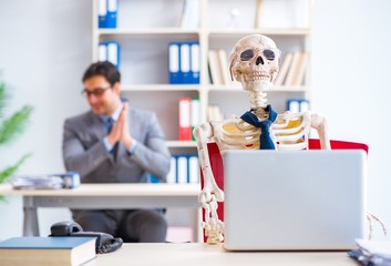 Businessman working with skeleton in office