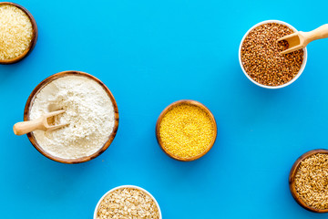Healthy food. Cereals - rice, oats, buckwheat - in bowls on blue background top view