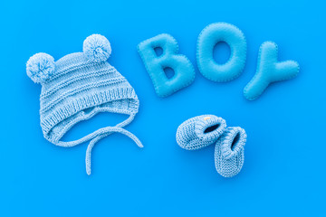 Children's birthday concept. Word boy near booties on blue background top view