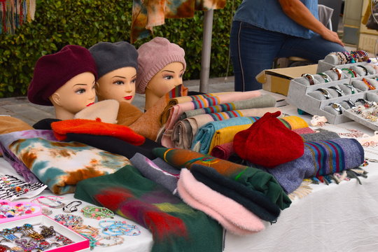 French style woollen autumn and winter colourful berets displayed on female mannequin heads Scarfs jewellery ladies hats for sale on a market stall in the popular for holiday Thuir South France Europe