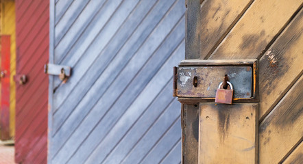 Many wooden doors closed with padlocks, perspective view.