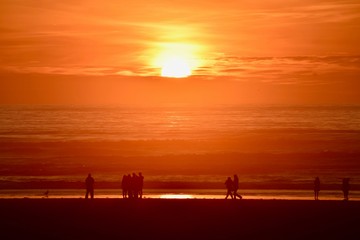 Fototapeta na wymiar People on beach at sundown 2- Seaside, Oregon
