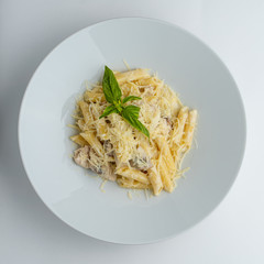 Creamy and cheesy seafood penne with parmesan cheese and basil isolated on white flat lay