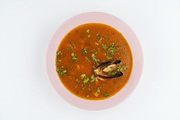 Hot spicy tomato soup with seafood and mussels isolated on white flat lay