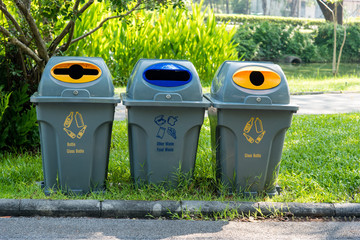 recycling and garbage bins in the public park on green grass background concept