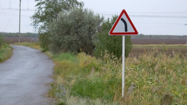 Road sign in the reeds, rainy weather, overcast